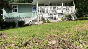 A two-story house with a covered porch and a small front yard. - Maggie's Place (Lookout Mountain)