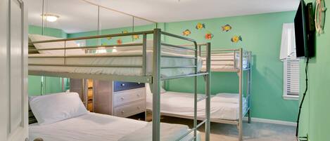 Habitación con literas, un aparador y un espejo.