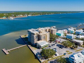 An aerial view of a coastal hotel with multiple buildings, a marina, and a dock.