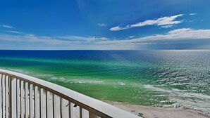 Uma varanda com vista para o oceano e a praia.