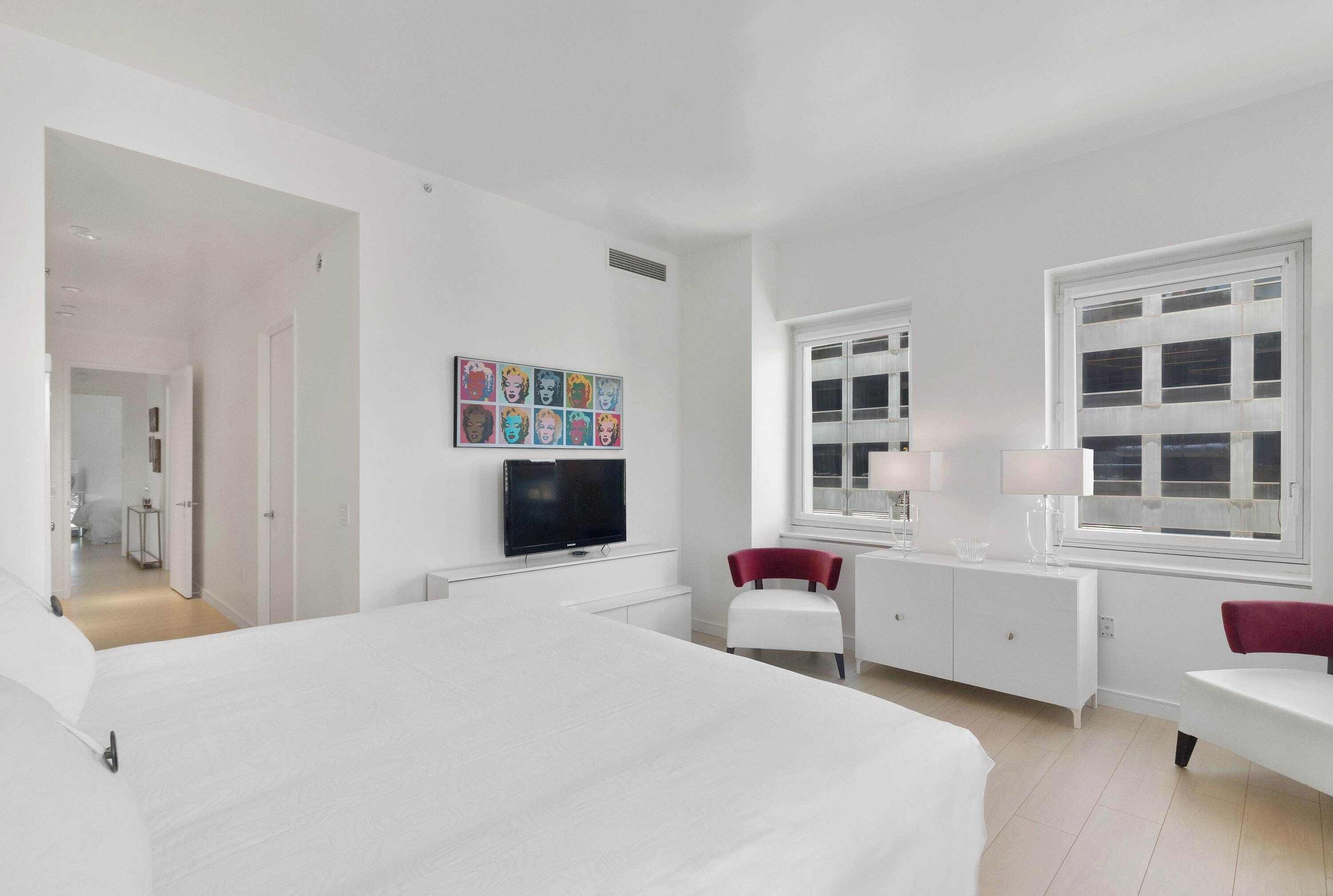 Habitación de hotel moderna con una cama grande, televisión, escritorio y ventana con vistas.