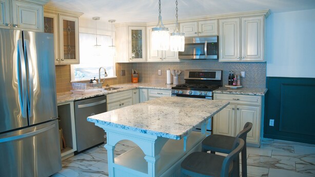 A kitchen with white cabinets, stainless steel appliances, a granite countertop, and pendant lighting. - 3BR/2BA Chic and Tranquil Magnolia House Near Boston (Everett)
