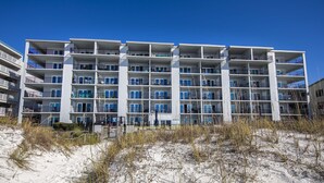 Un hôtel à plusieurs étages doté de balcons, situé près d’une plage de sable.