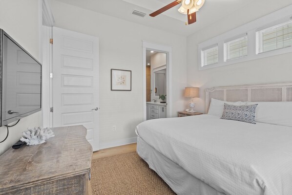 A bedroom with a large bed, a wooden dresser, a ceiling fan, and a window with blinds. - Prominence North #89C by Southern Vacation Rentals (Santa Rosa Beach)