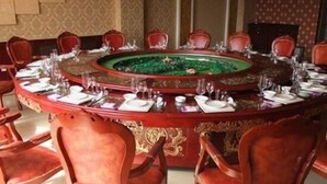 Una mesa redonda con sillas dispuestas para una comida.
