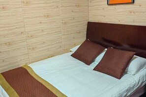 A single bed with a wooden headboard, a brown pillow, and a white bedspread. - Yandang Mountain Mingxiu Pavilion Inn (Yueqing)