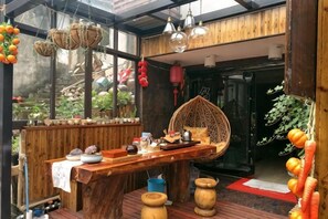 A wooden interior with a bar area, hanging baskets, and a large window. - Yandang Mountain Mingxiu Pavilion Inn (Yueqing)