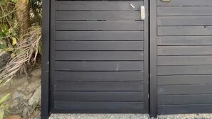 Une grille en métal noir, avec une petite plaque sur le côté droit.