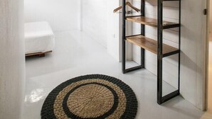 Un intérieur moderne avec un mur blanc, un plancher en bois et un tapis tissé aux motifs noirs et beige.