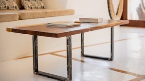 Een houten bijzettafel met metalen poten in een moderne woonkamer.