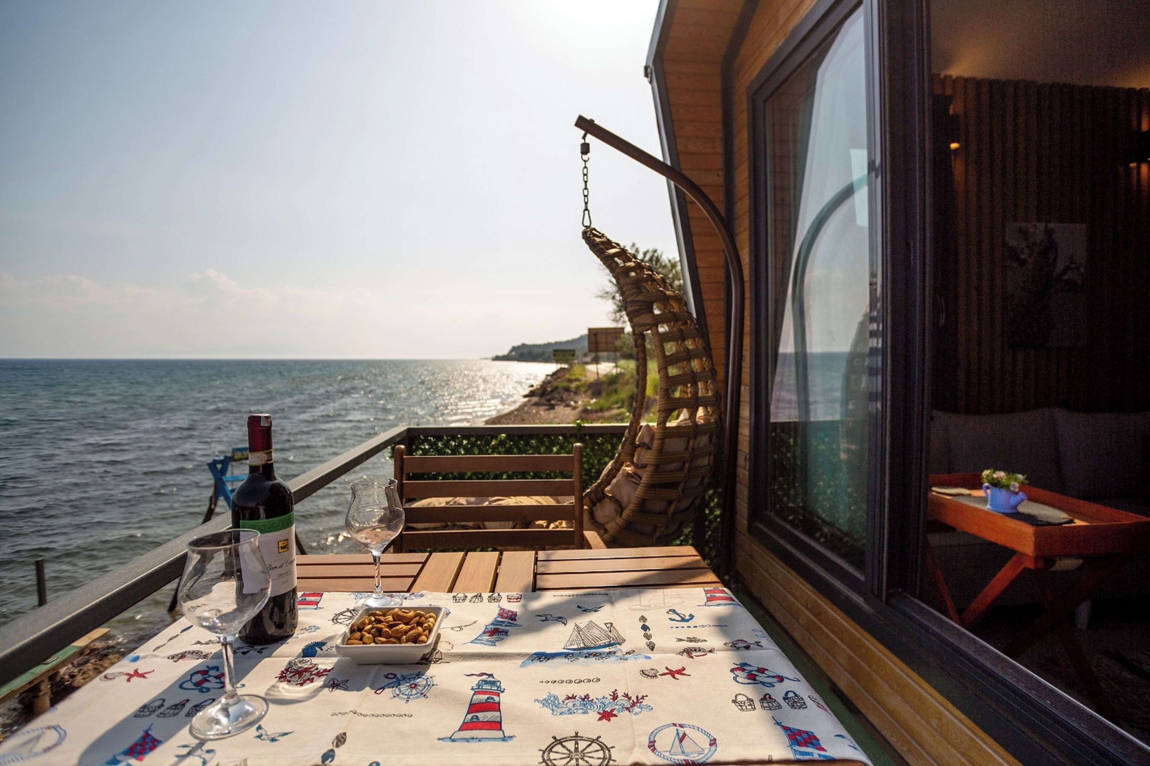 En balkon med et spisebord, med udsigt over havet.