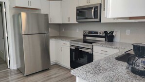 A modern kitchen with white cabinets, stainless steel appliances, and granite countertops.