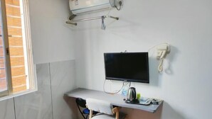 A small, clean room with a desk, chair, TV, and a phone. - Guilin Dihao Hotel (North Railway Station Branch) (Guilin)