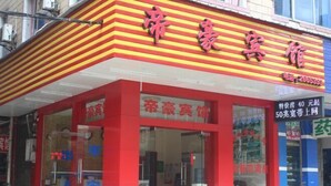 A red and yellow striped building with large glass windows and a sign that reads "帝豪宾馆". - Guilin Dihao Hotel (North Railway Station Branch) (Guilin)
