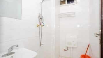 A small, clean bathroom with a sink, shower, and toilet.