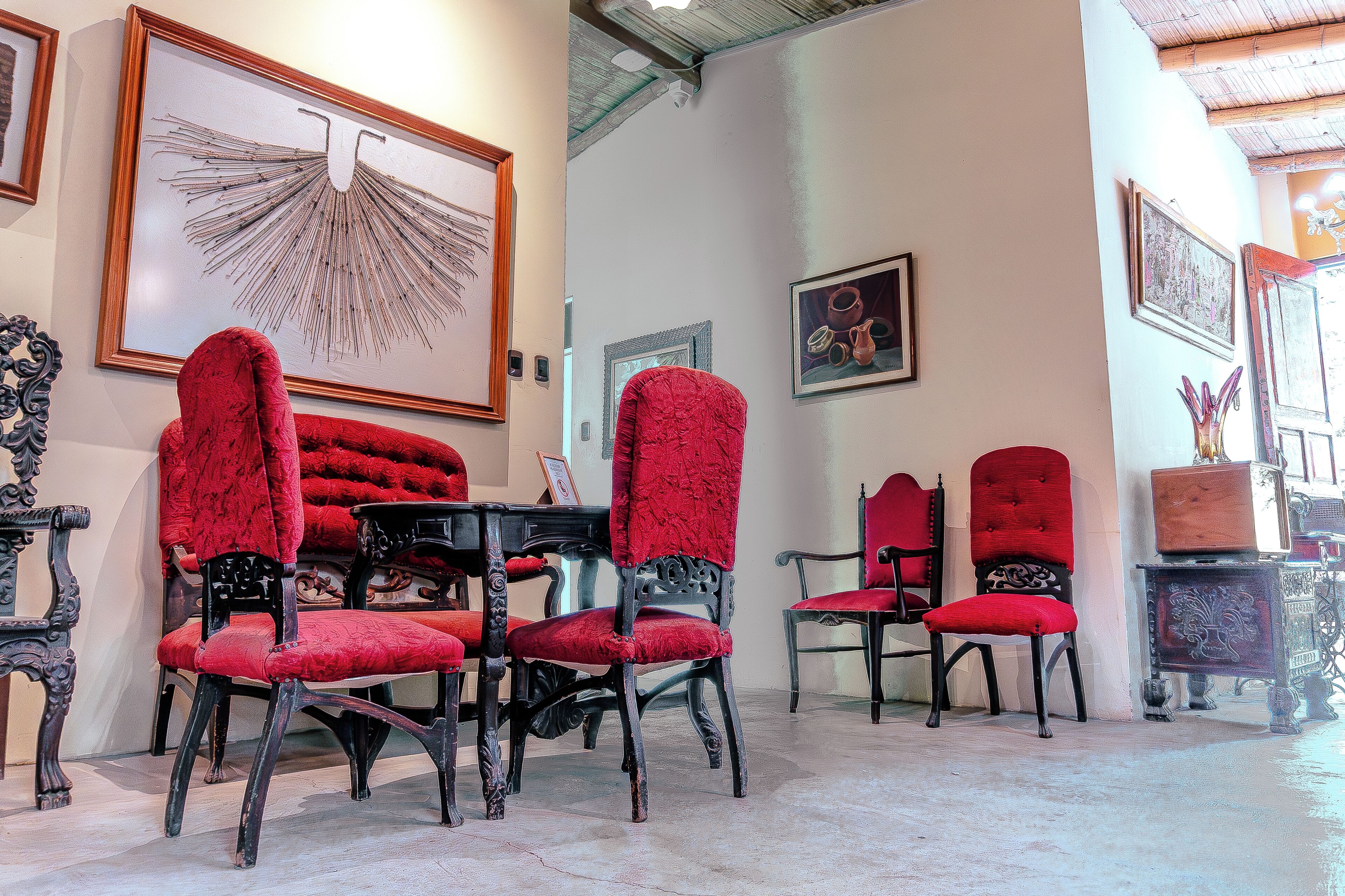 Une pièce comprenant une table à manger et des chaises, une grande œuvre d’art encadrée au mur et un meuble décoratif.