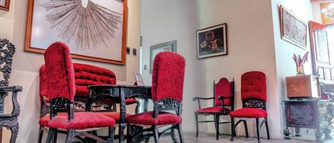 Une pièce comprenant une table à manger et des chaises, une grande œuvre d’art encadrée au mur et un meuble décoratif.