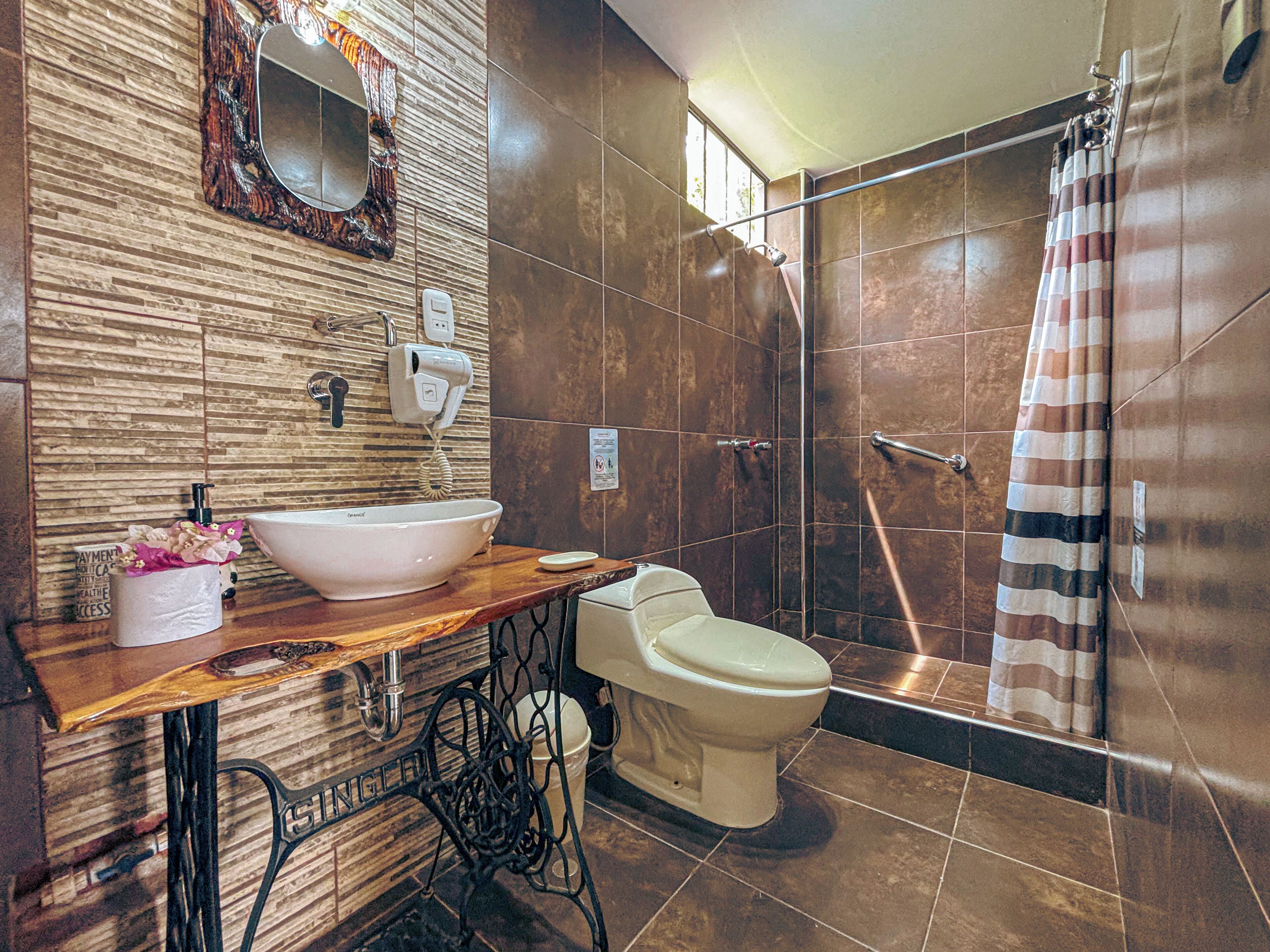 A bathroom with a sink, toilet, and shower.