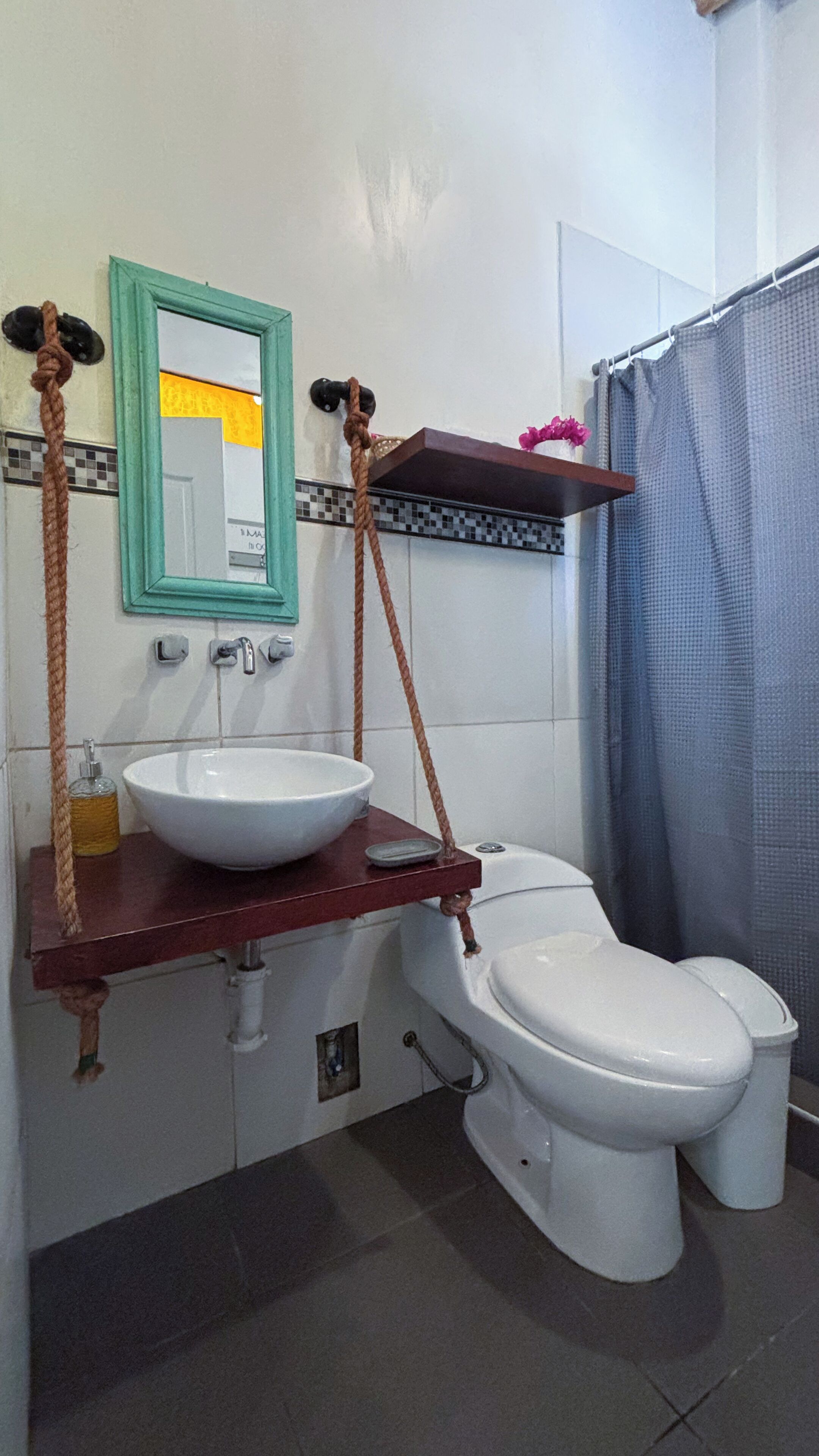 Un baño con lavamanos blanco, un espejo y un inodoro.