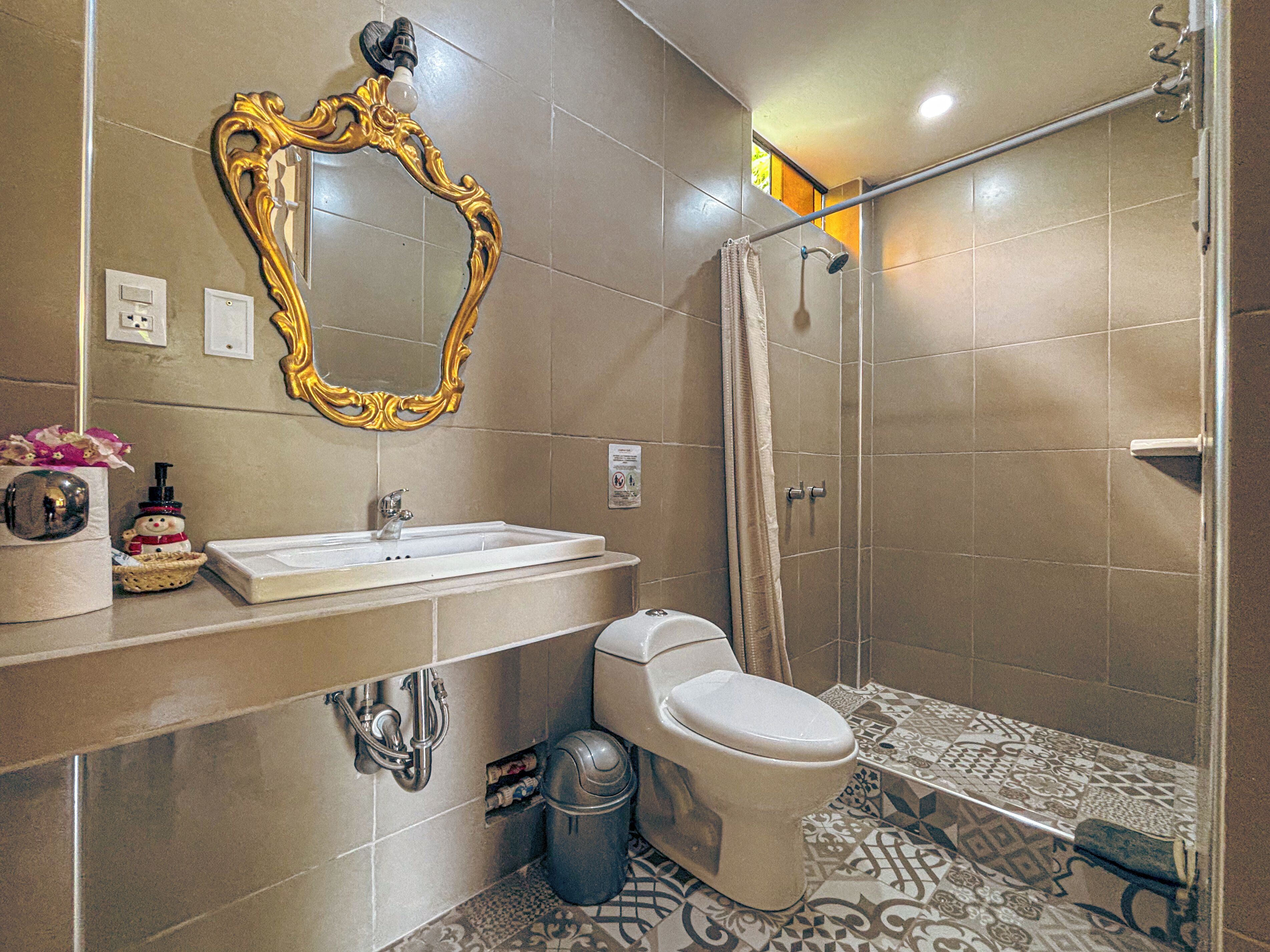 Un baño con lavamanos, inodoro y ducha.