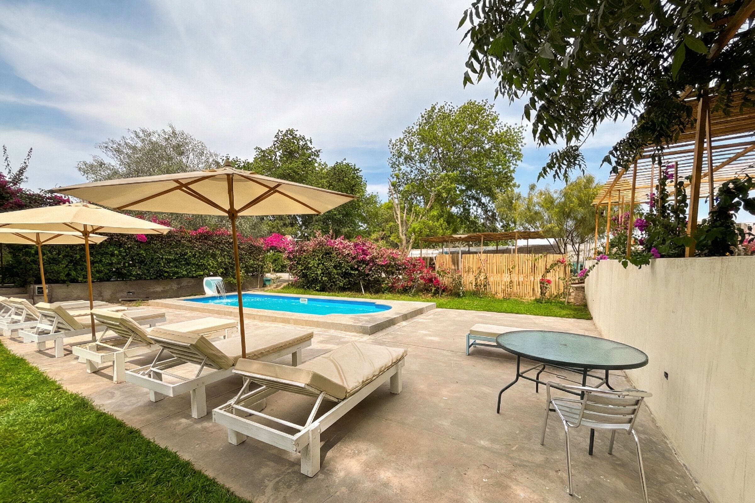 Een buitenzwembad, parasols voor strand/zwembad