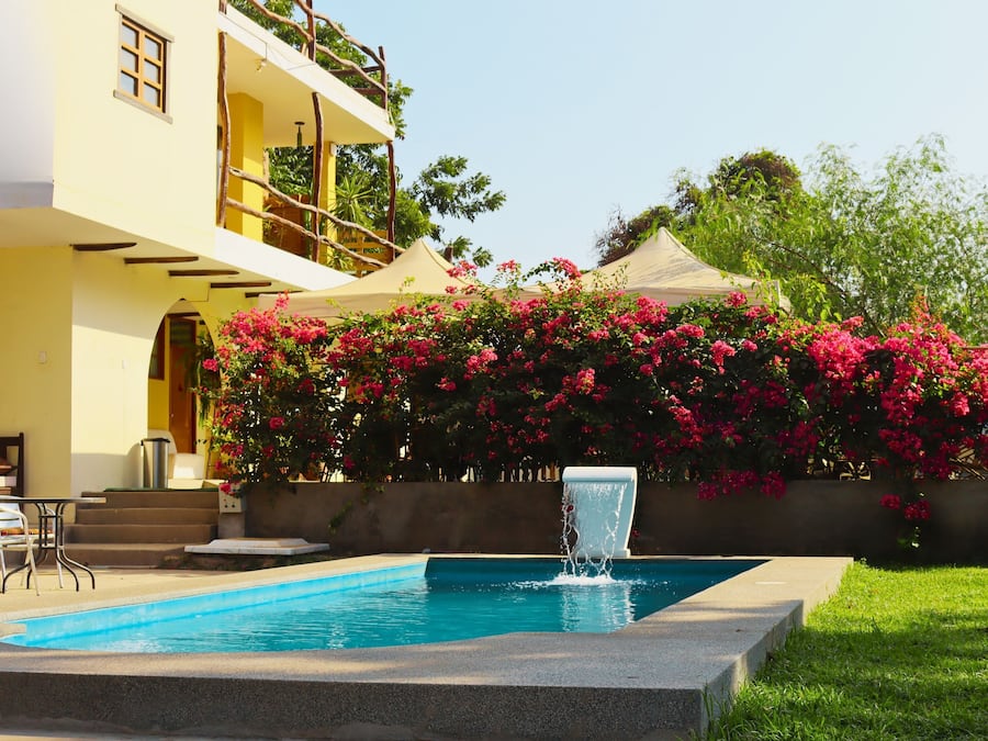 Een buitenzwembad, parasols bij het zwembad en ligstoelen
