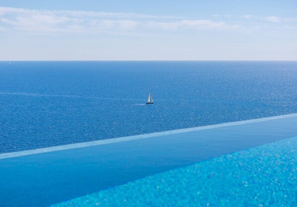 An infinity pool, a heated pool, sun loungers
