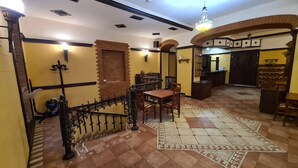 A spacious lobby with a checkered floor, a wooden piano, and a staircase with a wrought iron railing. - Hotel Jan-Hostel Jan (Yerevan)