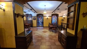 A hallway with a tiled floor, wooden furniture, and a stained glass window at the end. - Hotel Jan-Hostel Jan (Yerevan)