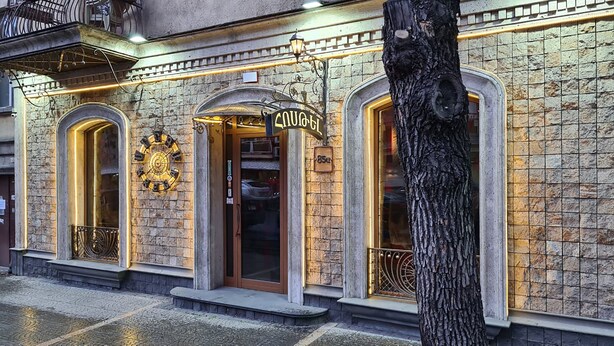 A building with a clock, a sign reading "COUCH," and a tree in front. - Hotel Jan-Hostel Jan (Yerevan)