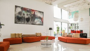Una sala de estar moderna con un sofá modular, una mesa de centro y un cuadro abstracto grande.