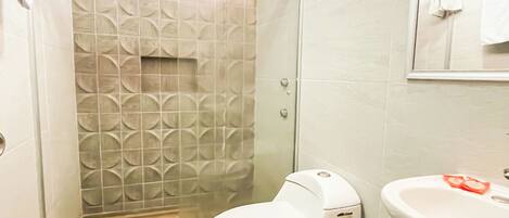 Un baño con ducha, inodoro y lavamanos.
