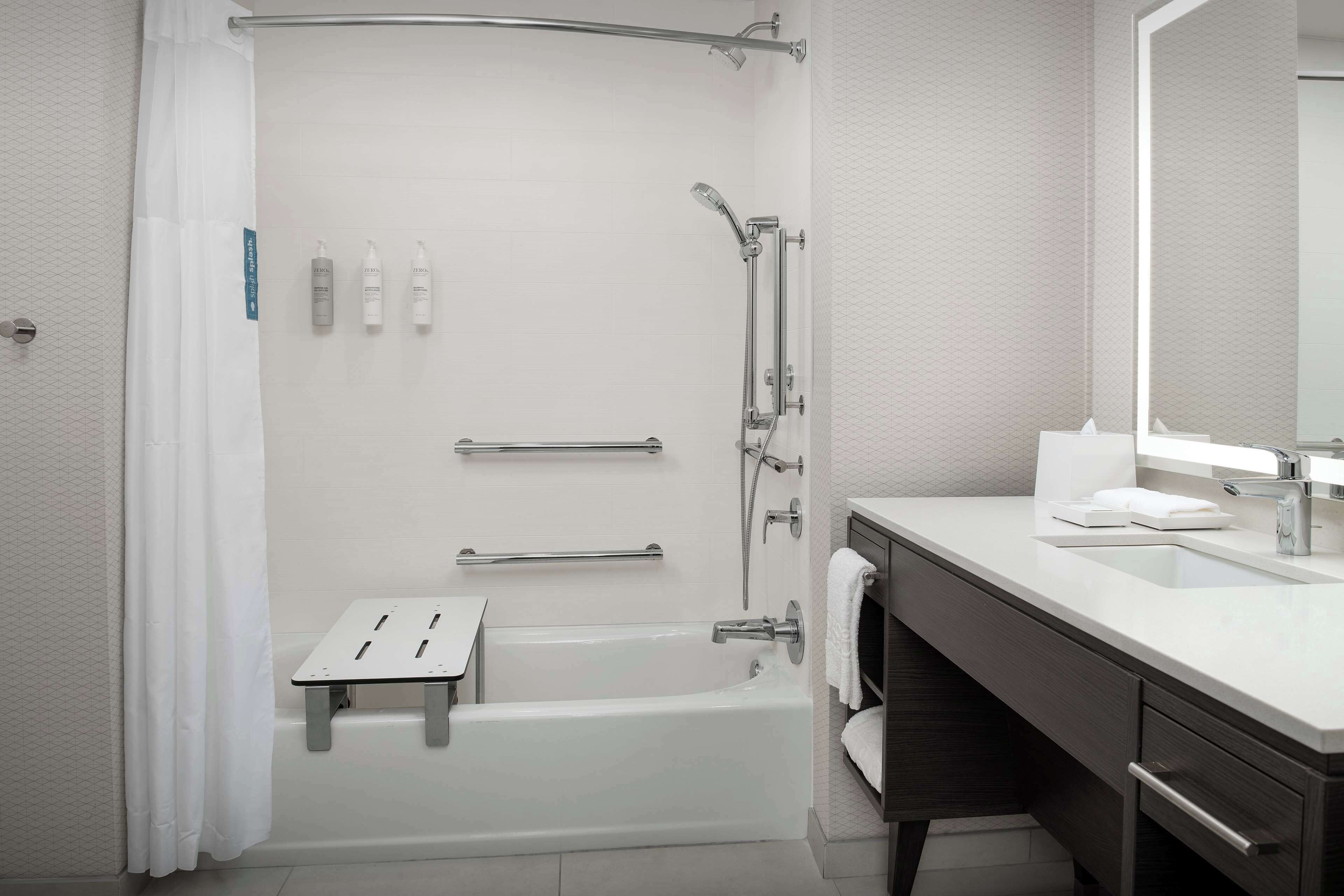 Un bagno moderno con vasca, doccia e mobile lavabo con specchio.