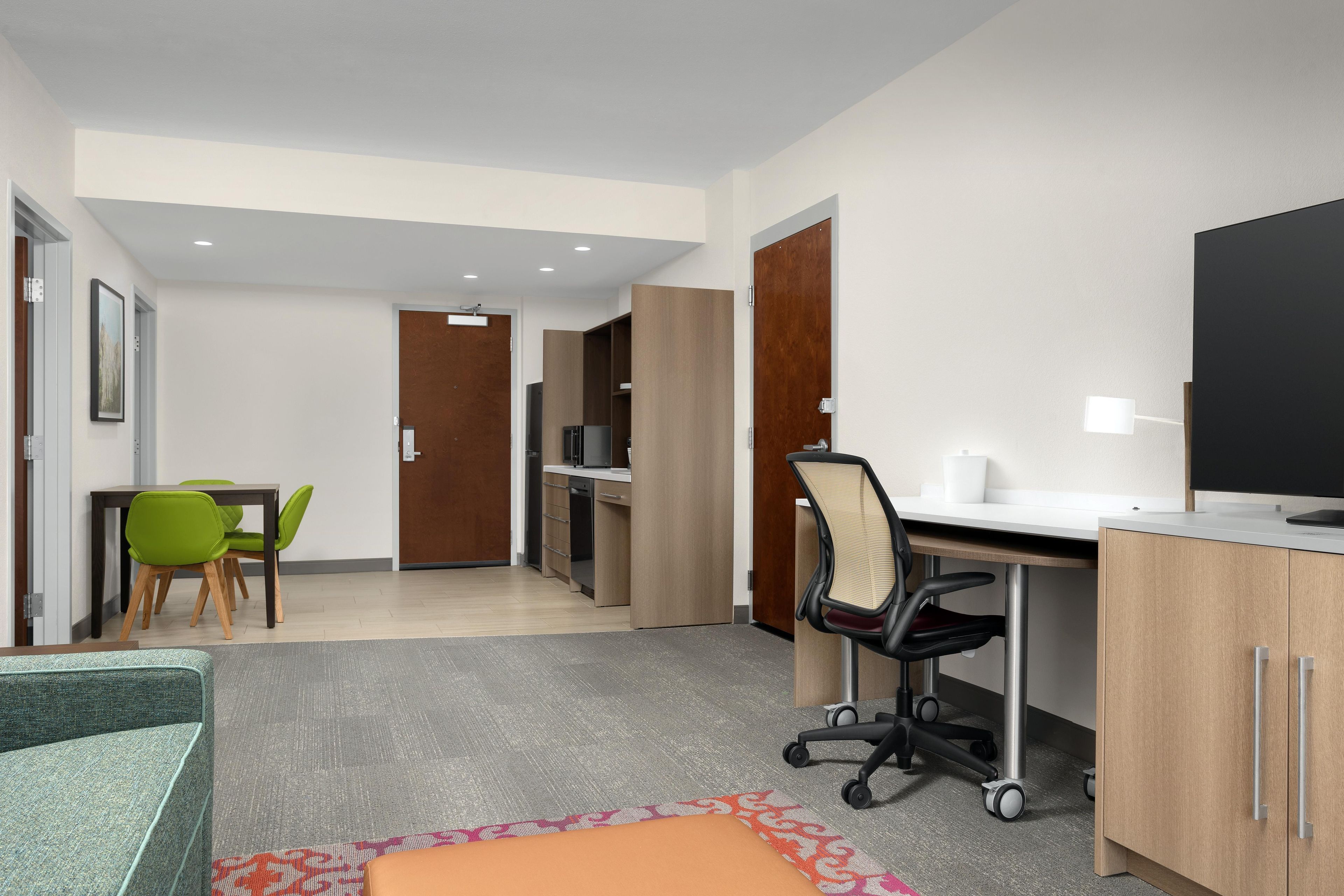 Une chambre d’hôtel moderne équipée d ’un bureau, d’une chaise et d’un téléviseur.