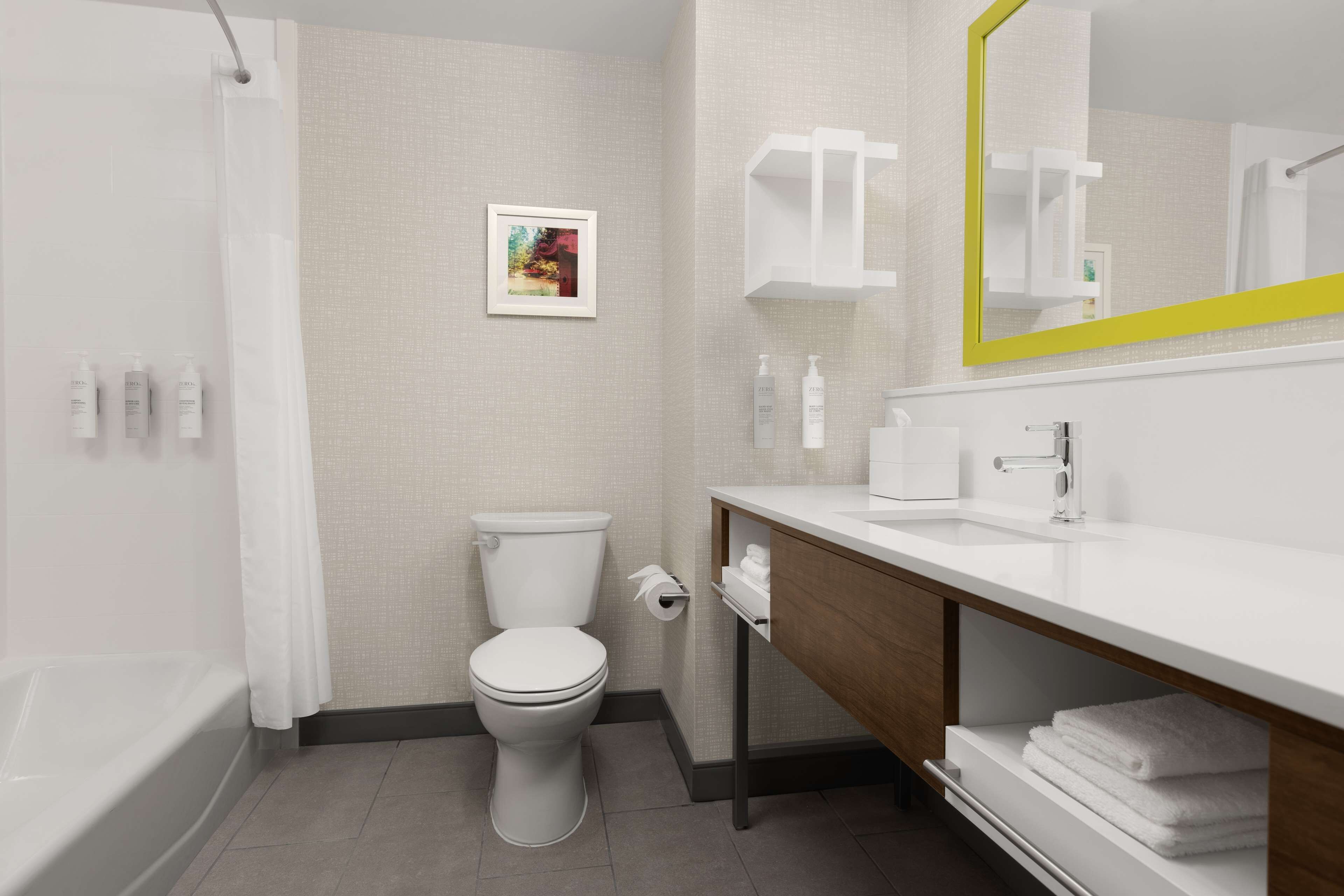 Une salle de bain moderne équipée de toilettes, d’une douche et d’un lavabo.