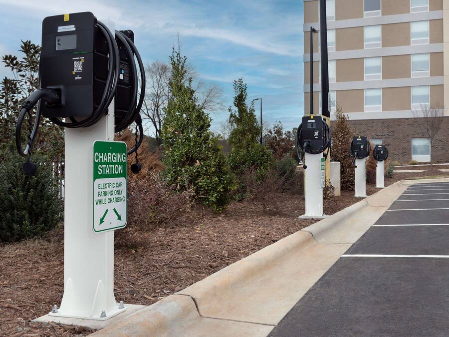 A parking area with electric car charging stations and a sign indicating parking is only allowed while charging.