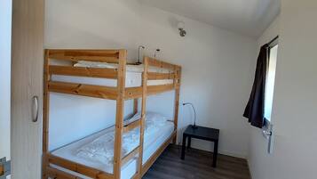 Una habitación con literas, un escritorio y una ventana.