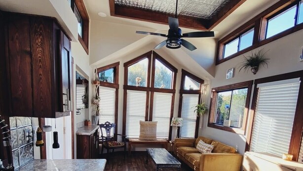 Una cocina amplia con una isla grande, piso de madera y un ventilador de techo.