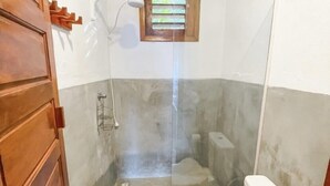 A bathroom with a shower, toilet, and a wooden door. - Pousada Estrela Peroba (Icapuí)
