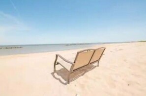 En strand med en enkelt tom strandstol.