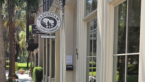 A building with a sign reading "HABERSHAM LAND COMPANY" and "SALES OFFICE" on the ground floor. - Low Country Cottage in Beautiful Habersham (Beaufort)
