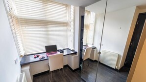 A compact bedroom with a desk, chair, and a bed. - Cosy Studio Close to the University (Birmingham)