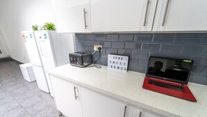 A kitchen with white cabinets, a toaster, a laptop, and a sign that reads "HOME SWEET HOME". - Cosy Studio Close to the University (Birmingham)