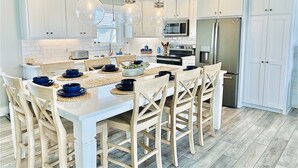 Een moderne keuken met witte kasten, een centraal eiland met blauwe kommen en hangende吊灯