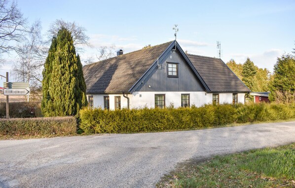 A single-story house with a sloped roof, a chimney, and a small attached shed. - Amazing home in Klagstorp with WiFi (Klagstorp)
