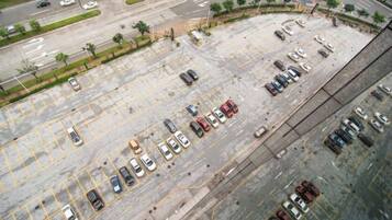 An aerial view of a parking lot with multiple rows of parked cars.