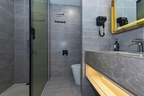 A modern bathroom with a glass shower enclosure, a vanity with a marble countertop, and a mirror with a gold frame. - Wei Hotel Fan (Beijing Wangjing SOHO Yitong Subway Station) (Beijing)