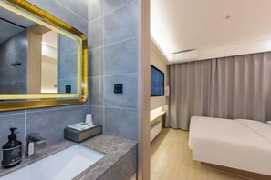 A modern hotel room with a large mirror, a built-in sink, a bedside table, a TV, and a bed. - Wei Hotel Fan (Beijing Wangjing SOHO Yitong Subway Station) (Beijing)