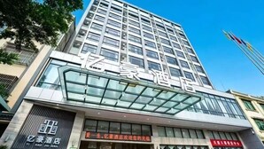 A modern hotel building with a prominent glass facade and signage indicating it is a hotel. - Yihao Hotel (Qionghai)