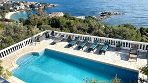 A pool with lounge chairs and a view of the sea. - Maison Paradisiaque A Rosas A Proximite DES Plages (CANYELLES ALMADRABA (AJUNTAMENT ROSES))